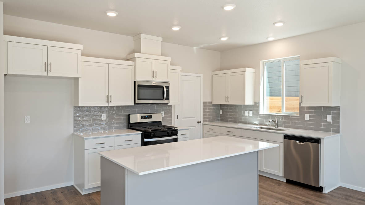 Monrovia kitchen with stainless steel appliances, island, window, and shaker style cabinetry