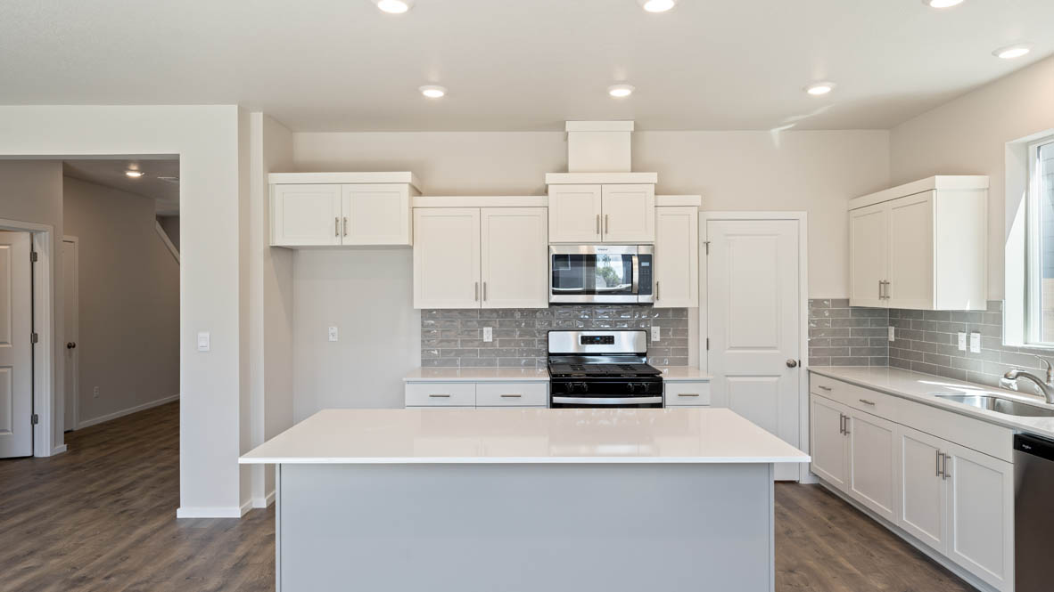 Monrovia kitchen with stainless steel appliances, island, window, and shaker style cabinetry