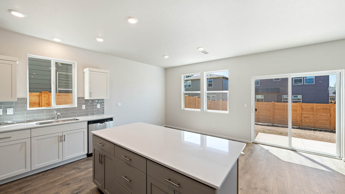 Monrovia kitchen with stainless steel appliances, island, window, and shaker style cabinetry