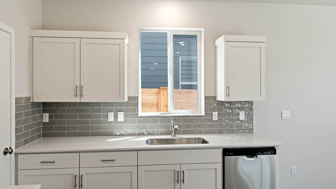 Monrovia kitchen with stainless steel appliances, island, window, and shaker style cabinetry