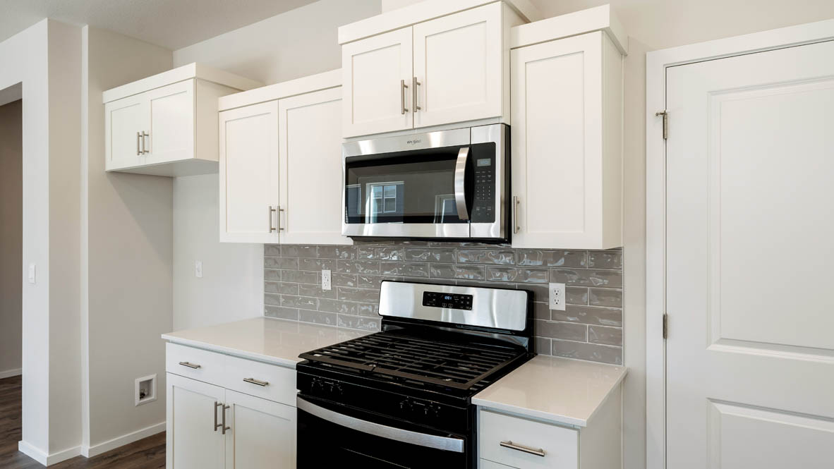 Monrovia kitchen with stainless steel appliances, island, window, and shaker style cabinetry