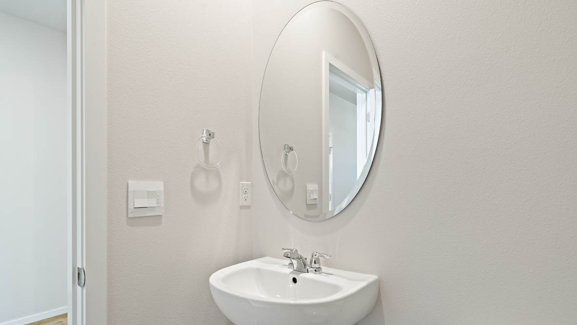 Monrovia powder room with single sink vanity, mirror, and toilet