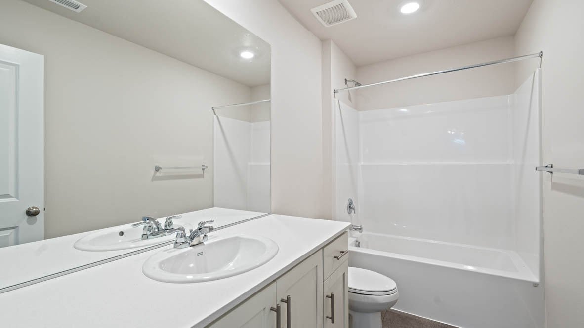 Monrovia secondary bathroom with quartz countertops, toilet, mirror, and shower tub