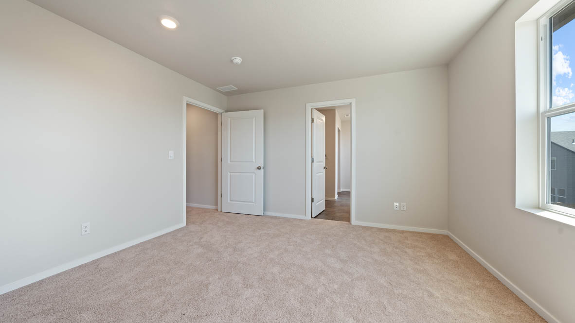 Monrovia primary bedroom with closet, windows, carpet, and white walls