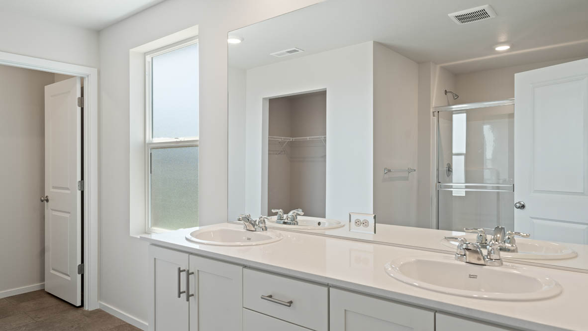 Monrovia Primary bathroom with quartz countertops, toilet, mirror, and shower tub