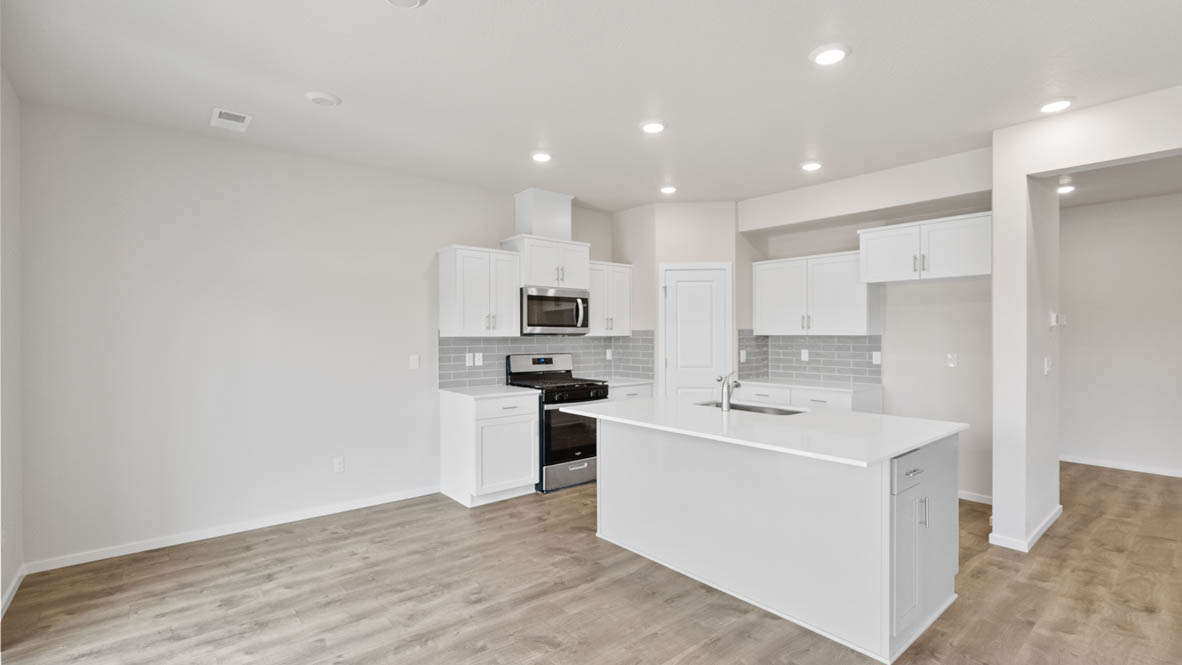 Monrovia kitchen with island, stainless steel appliances, and windows