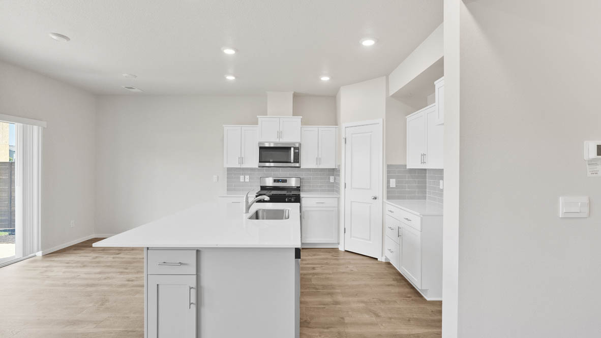 Monrovia kitchen with island, stainless steel appliances, and windows