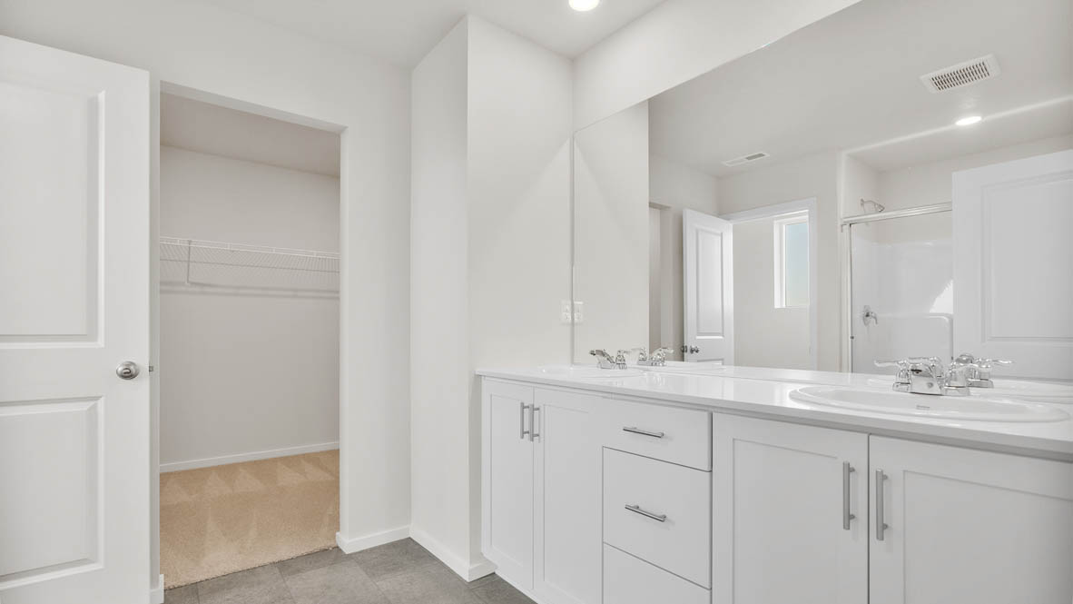 Monrovia primary bathroom with double vanity sink, mirror, quartz countertops, cabinets