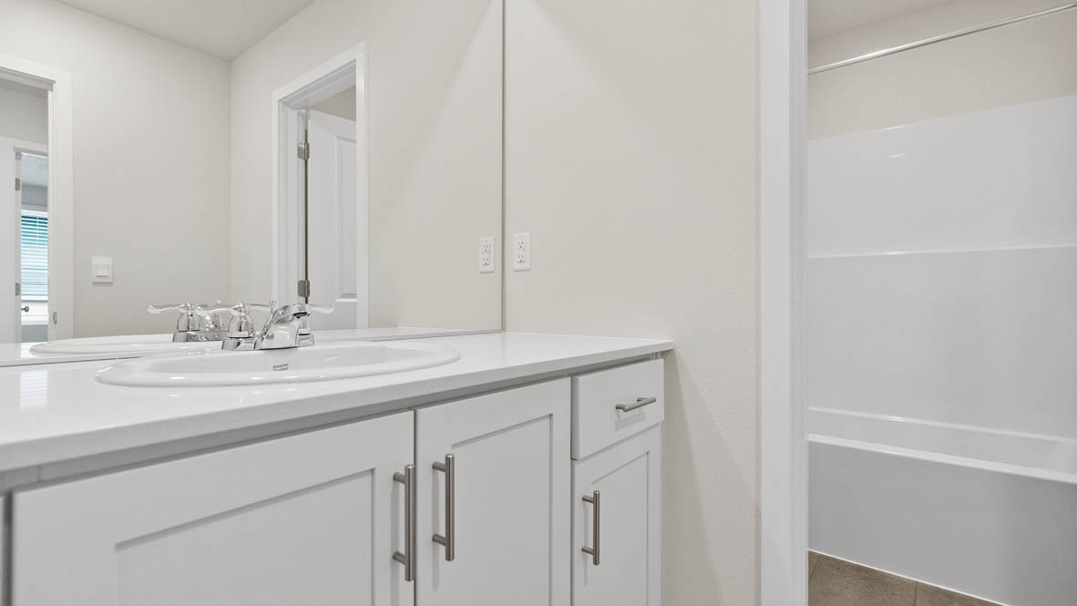 Monrovia bathroom with sink, mirror, showertub, quartz countertops, cabinets