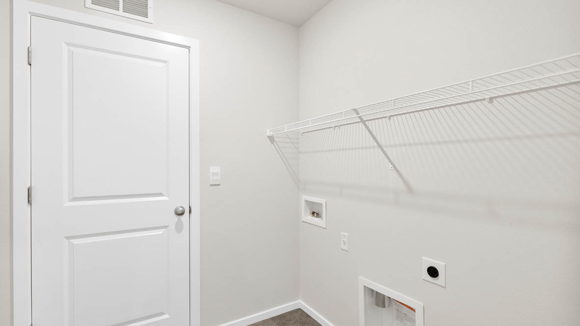 Monrovia laundry room with white wire shelving, white walls, and flooring