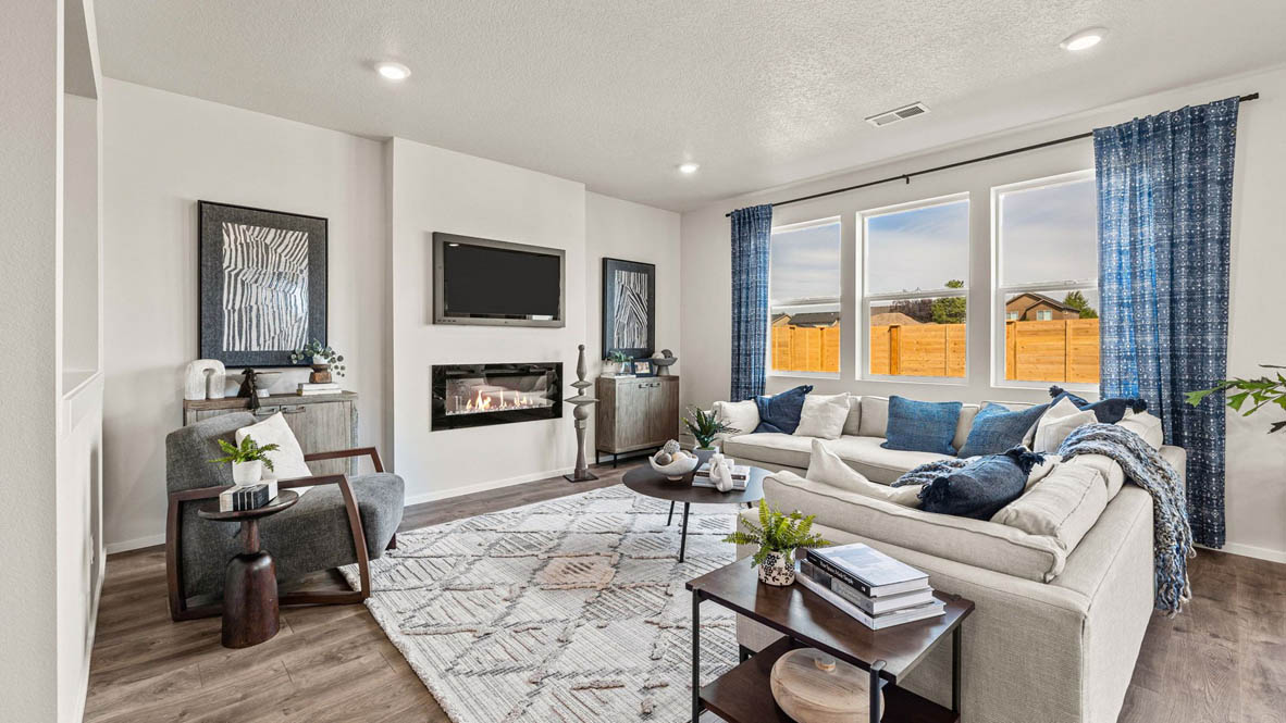 Monrovia Great room with L shaped sectional couch facing the fireplace and TV over an area rug with a coffee table and chair in the corner