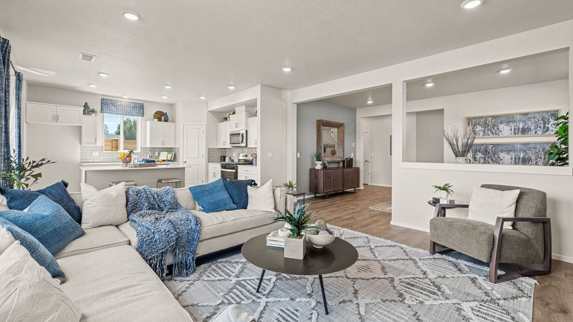 Monrovia Great room with L shaped sectional couch facing the fireplace and TV over an area rug with a coffee table and chair in the corner