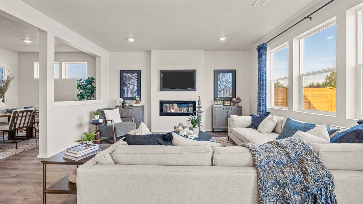 Monrovia Great room with L shaped sectional couch facing the fireplace and TV over an area rug with a coffee table and chair in the corner