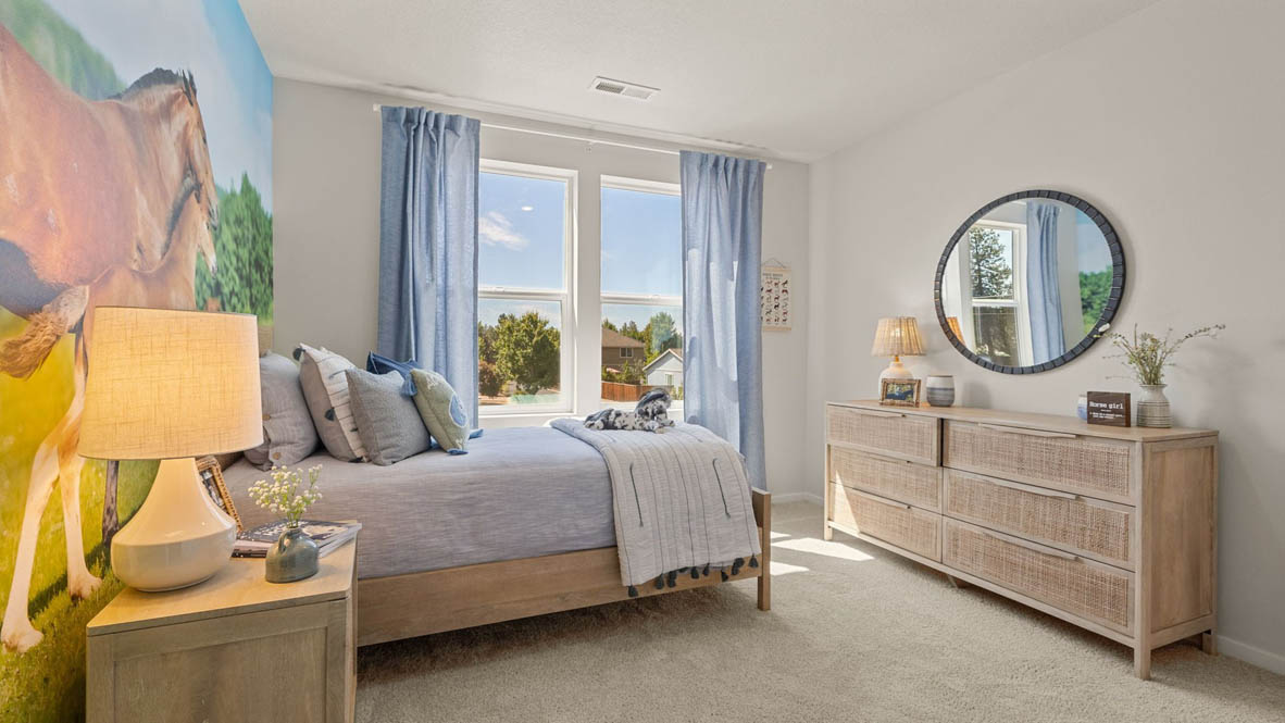 Monrovia Bedroom with horse theme, blue bedding and window drapes, large horses on the wallpaper, light wood furniture, and carpeting
