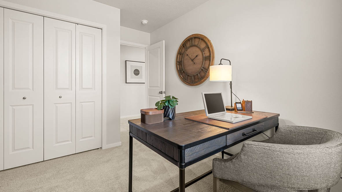 Monrovia Den set up as an office with a desk, media cabinet, and plants