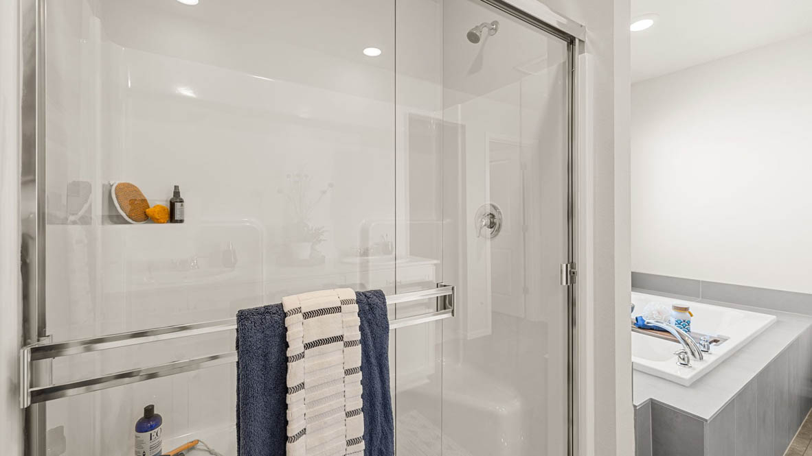 Monrovia Primary bathroom with walk in shower with glass doors and tub