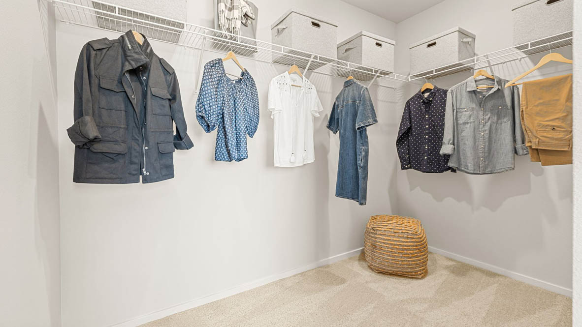 Monrovia Walk in closet with clothing hanging and storage boxes above