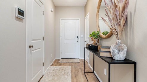 Lowrie Estates Entry with runner carpet and entry table with round mirror above