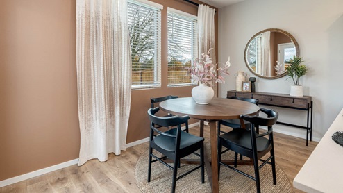 Lowrie Estates dining room with round table set for four and a round mirror with a wall table underneath