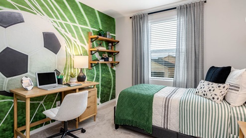 Lowrie Estates soccer themed bedroom with twin bed and soccer wall paper and desk set up