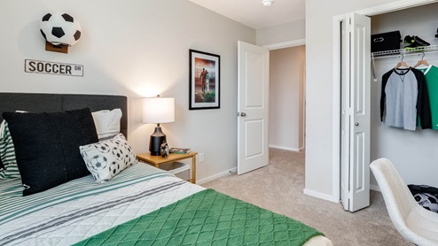 Lowrie Estates soccer themed bedroom with twin bed and soccer wall paper and desk set up