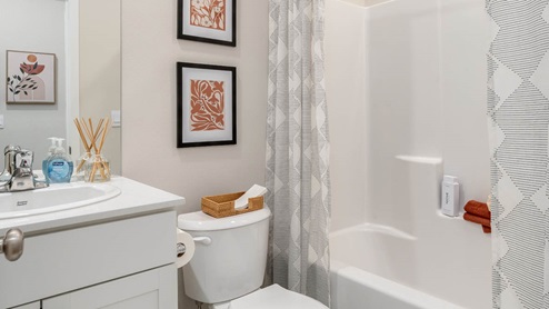 Lowrie Estates secondary bathroom with tub shower and drapes with a single sink vanity