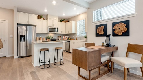 Scholls Meadow Kitchen with stools, kitchen island, stainless steel appliances, quartz countertops, white shaker cabinets, windows, paintings
