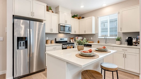 Scholls Meadow Kitchen with stools, kitchen island, stainless steel appliances, quartz countertops, white shaker cabinets, windows