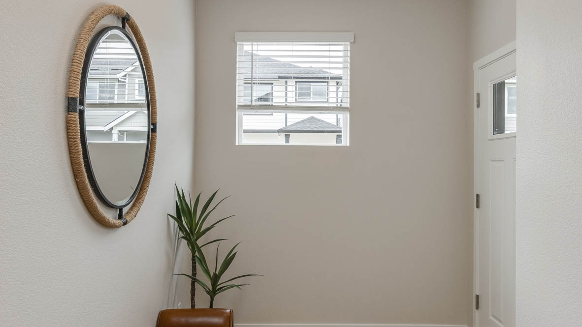 Davis Estates Entry with a circular mirror, an indoor plant, entry door, entry window, and white walls