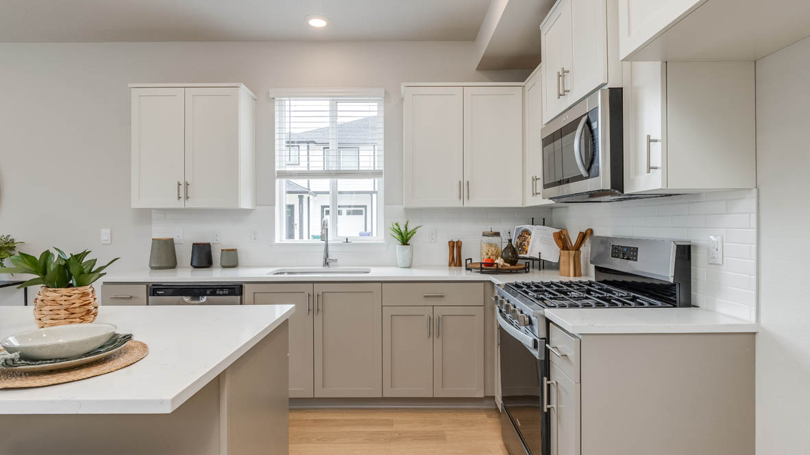 Davis Estates Kitchen with island, barstool chairs, quartz countertops, stainless steel appliances, windows, and laminate flooring