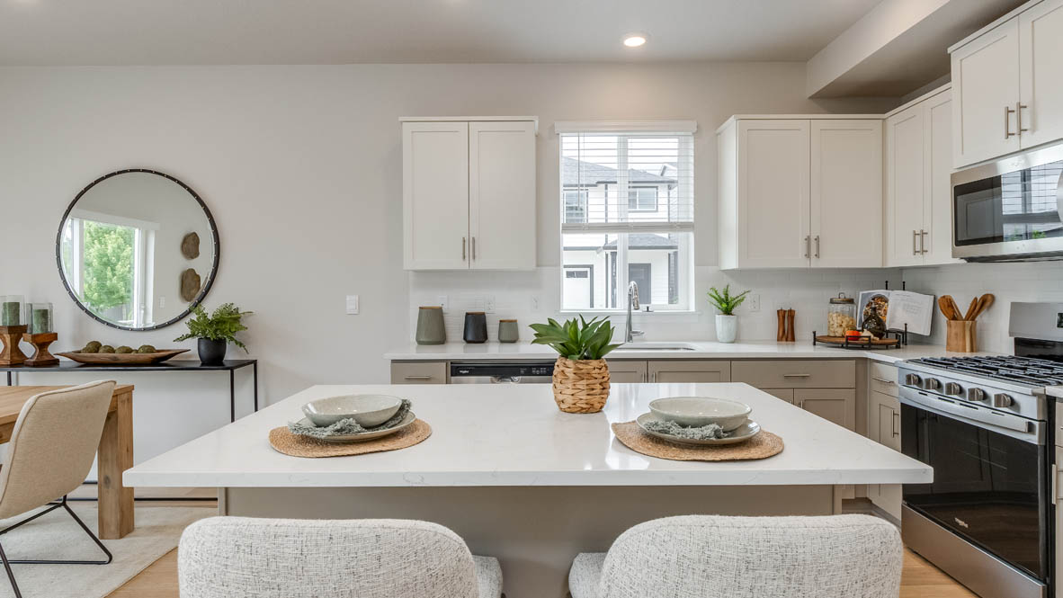 Davis Estates Kitchen with island, barstool chairs, quartz countertops, stainless steel appliances, windows, and laminate flooring