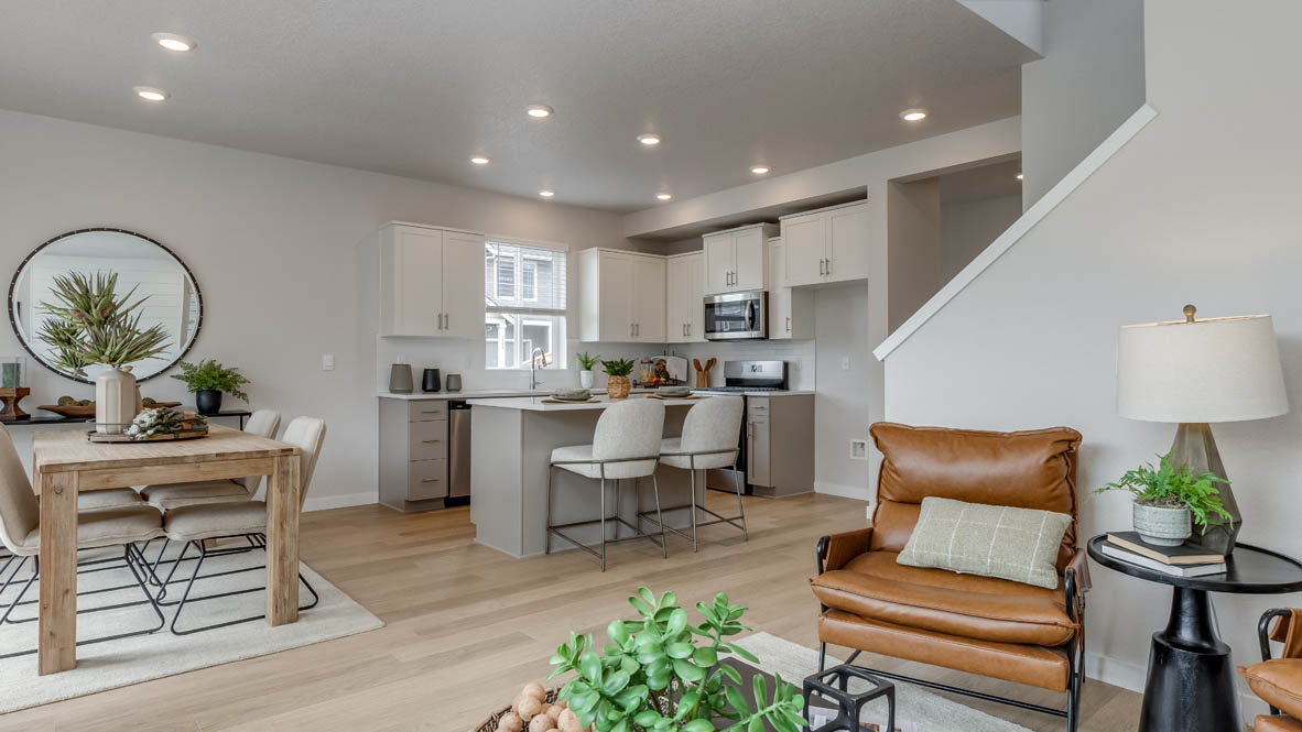 Davis Estates Great Room with black coffee table, orange chair, carpet, lamp, laminate flooring, and kitchen