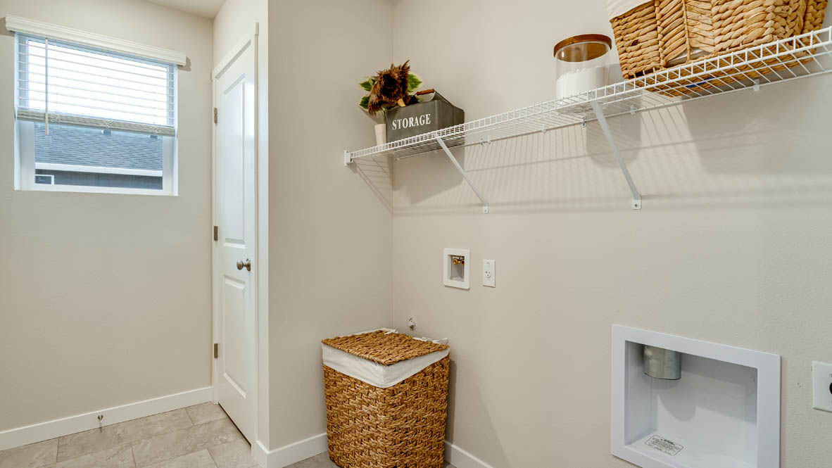 Davis Estates laundry room with a hamper, paintings, and white wire shelving