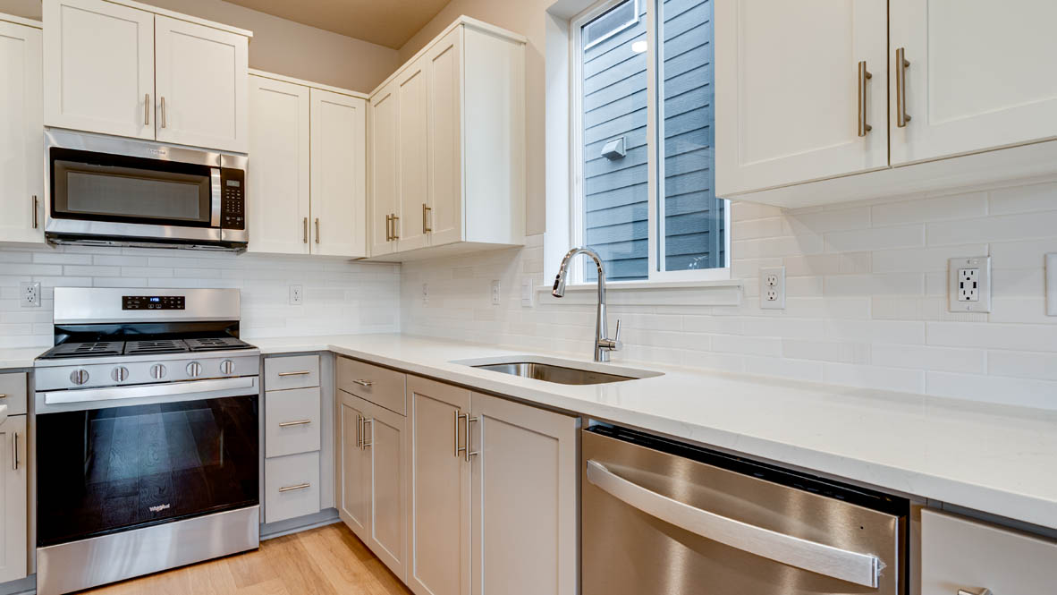 Davis Estates kitchen with shaker style cabinets and white quartz countertops and stainless steel appliances
