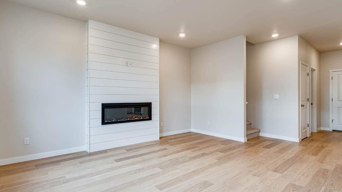 Davis Estates great room with white walls and electric fireplace