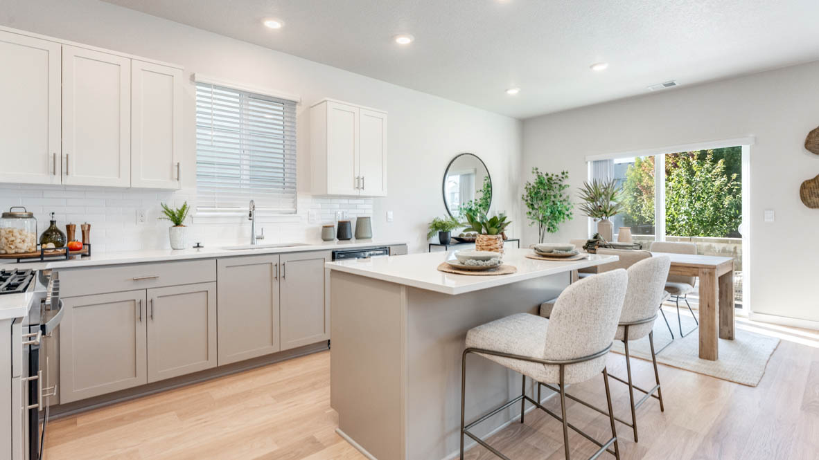 Davis Estates Kitchen with island, barstool chairs, quartz countertops, stainless steel appliances, windows, and laminate flooring