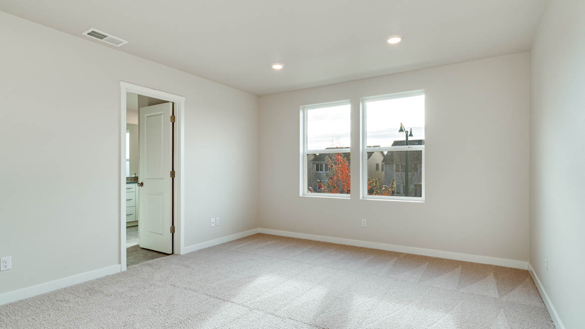 Davis Estates primary bedroom with carpeting and white walls and windows