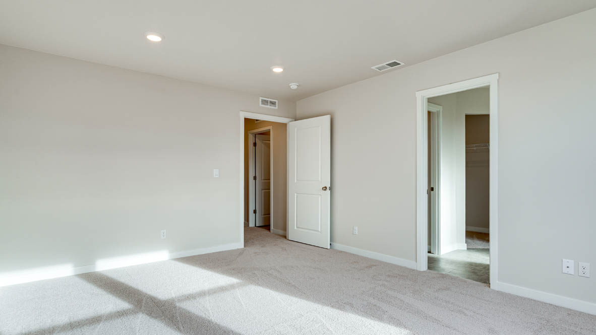 Davis Estates primary bedroom with carpeting and white walls and windows