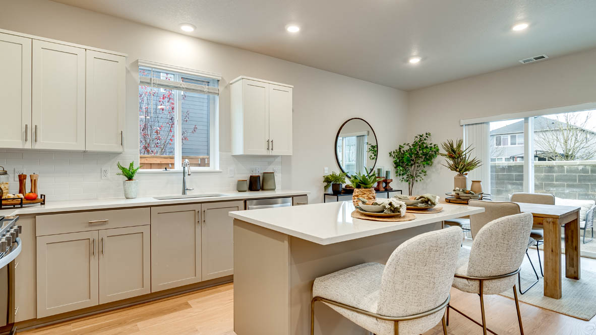 Davis Estates Kitchen with island, barstool chairs, quartz countertops, stainless steel appliances, windows, and laminate flooring