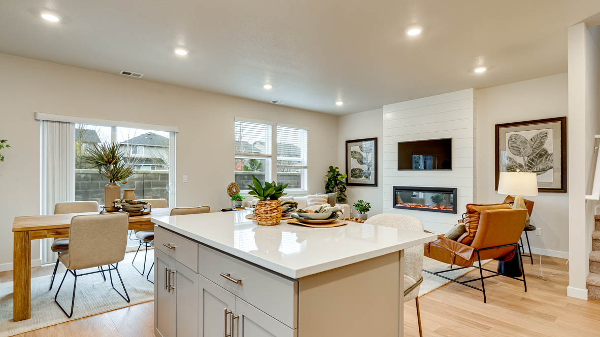 Davis Estates Kitchen with island, barstool chairs, quartz countertops, stainless steel appliances, windows, and laminate flooring