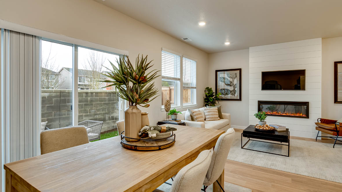 Davis Estates Dining Room with table and four chairs, decorative plant, circle mirror, side table, sliding glass window