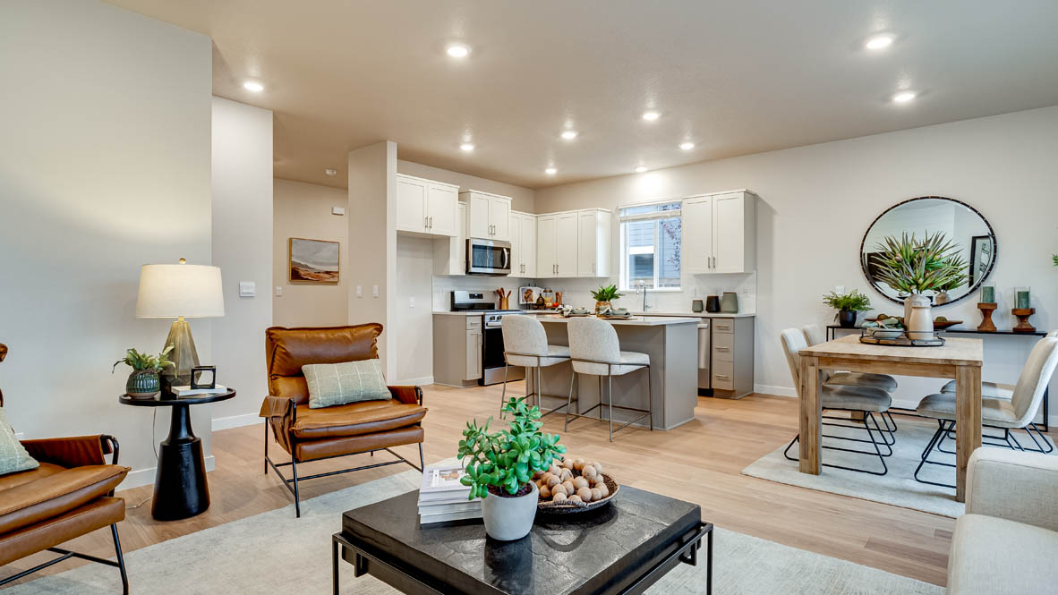 Davis Estates Great Room with electric fireplace, white couch, black coffee table, windows, orange chair, carpet, and laminate flooring