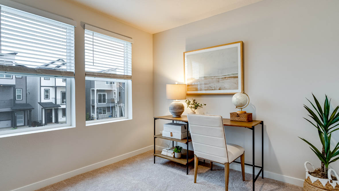 Davis Estates Bedroom with desk and chair looking over a painting, a plant, carpet, and windows