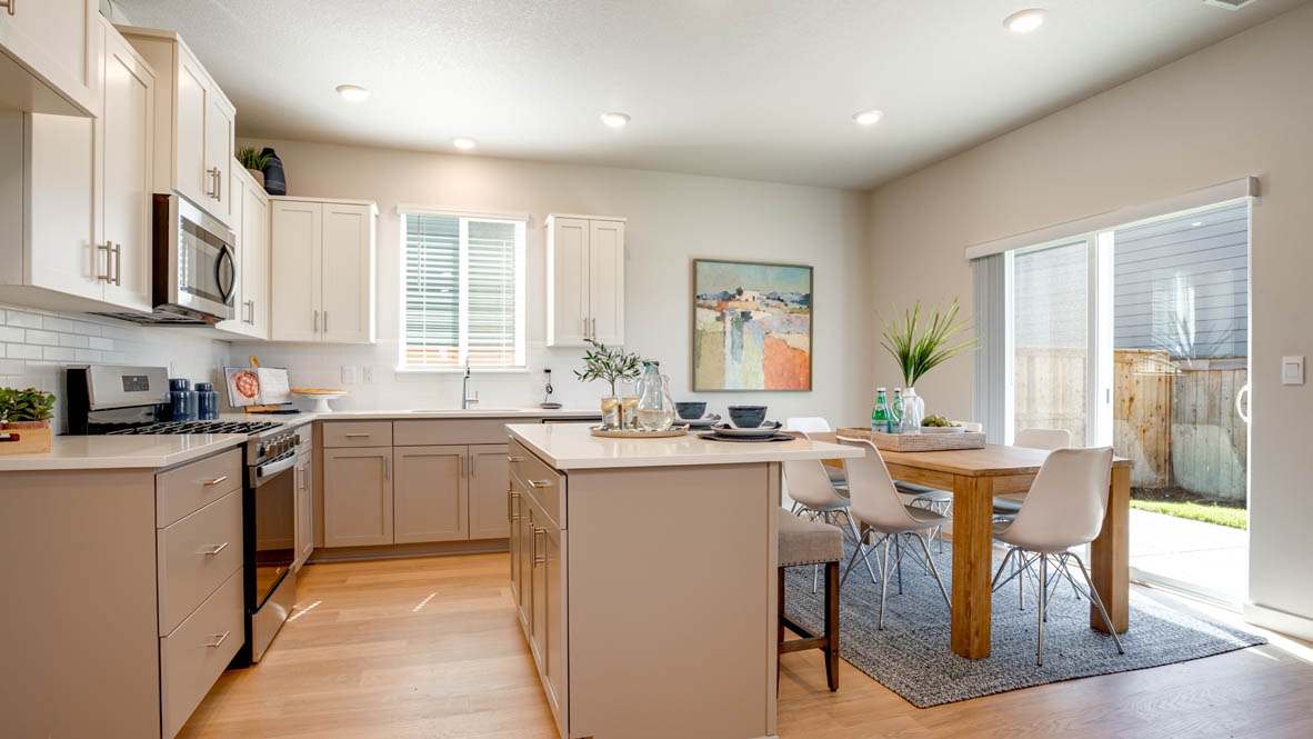 Davis Estates kitchen with laminate flooring, stainless steel appliances, cabinets, window, solid surface countertops