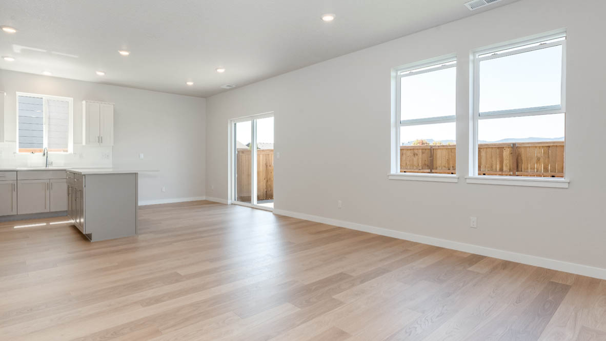 Davis Estates dining room with laminate flooring, windows, and the kitchen in the background