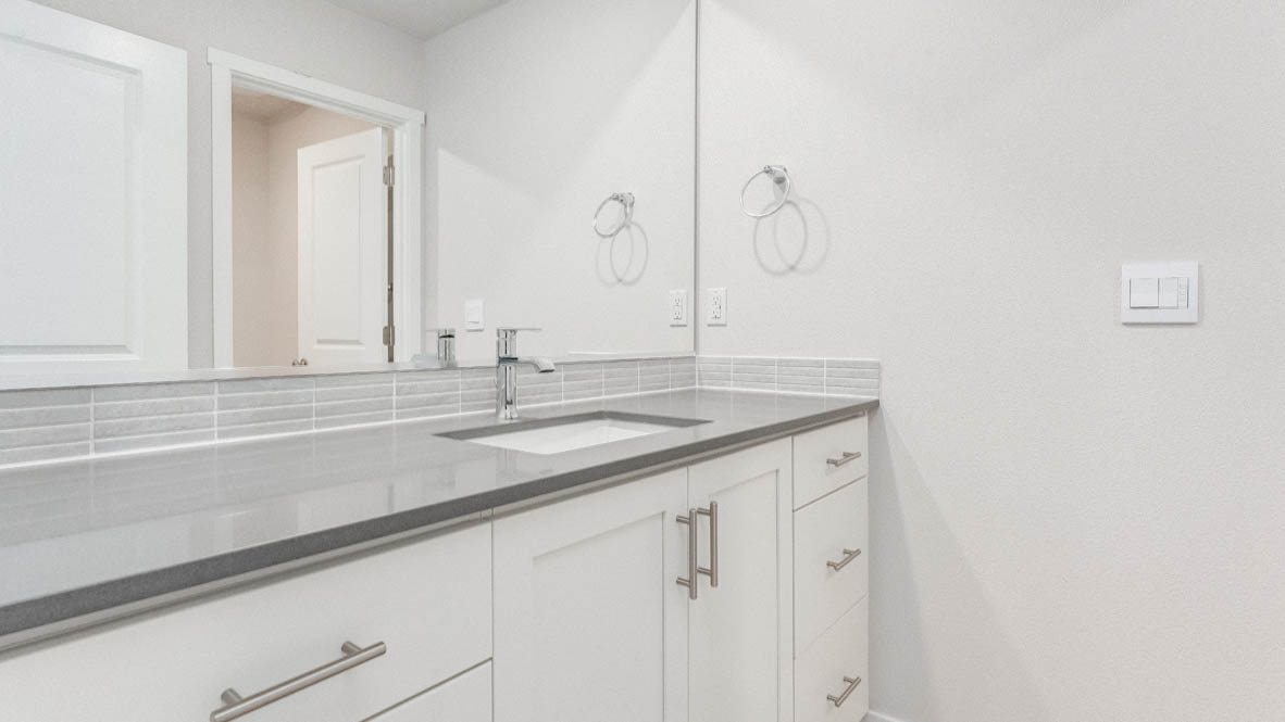 Davis estates bathroom with solid surface countertops, mirror, and cabinets