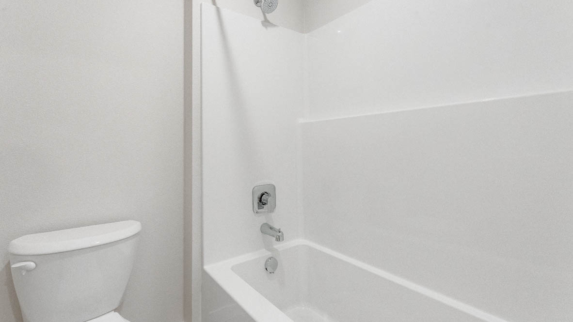Davis Estates bathroom with toilet, and white shower tub