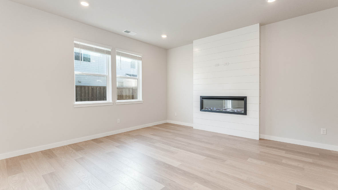 Davis Estates great room with fireplace, laminate flooring, and windows