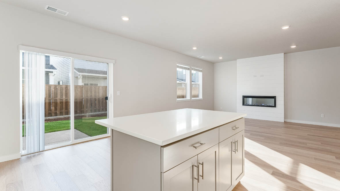 Davis Estates dining room with laminate flooring, windows, and the kitchen in the background