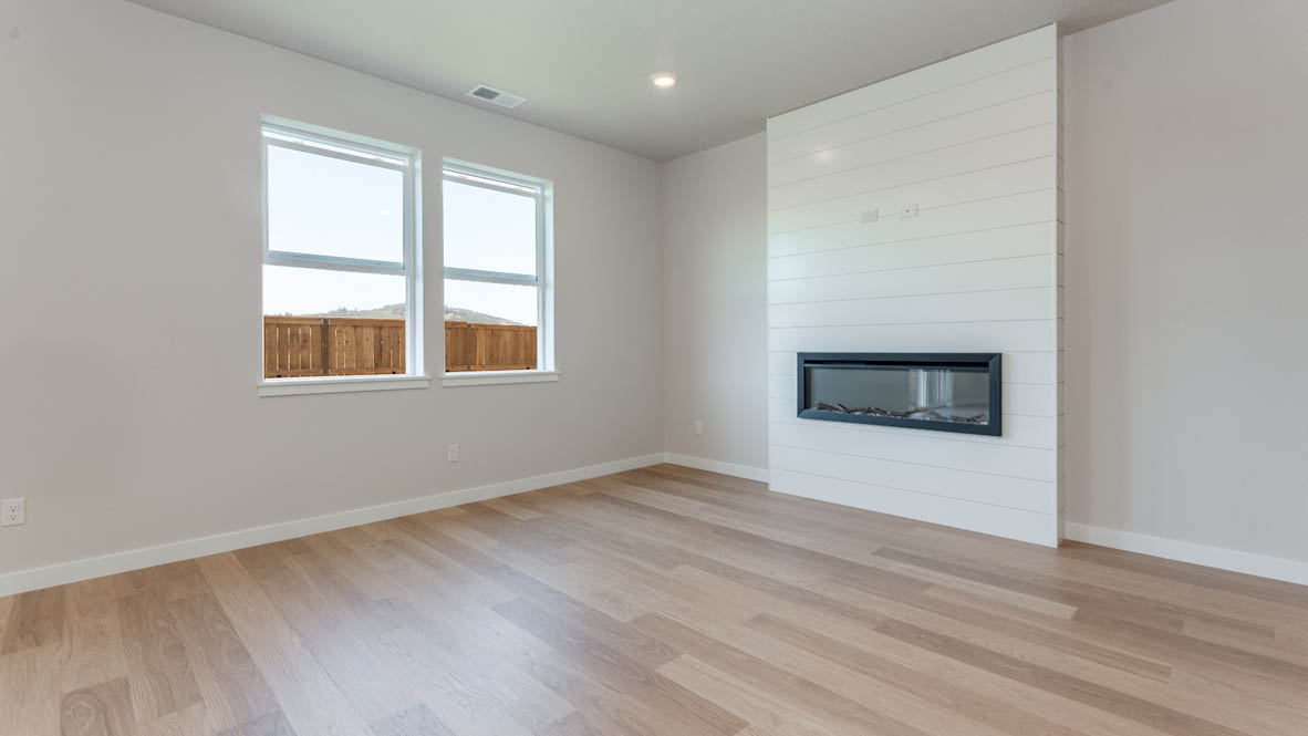 Davis Estates great room with fireplace, laminate flooring, and windows